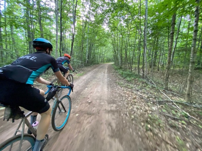 Two riders on a wooded road